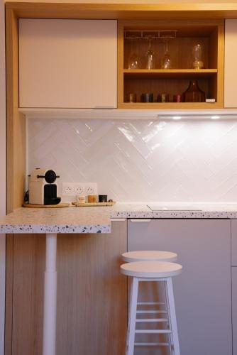 une cuisine avec un comptoir et un tabouret. dans l'établissement La RESIDENCE, à Roquebrune-Cap-Martin