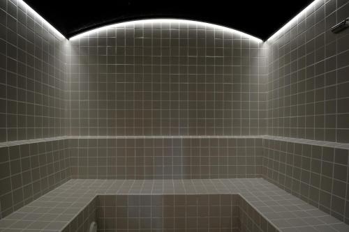 a tiled bathroom with a bath tub with lights at Prinsotel Alba & Spa in Cala d´Or