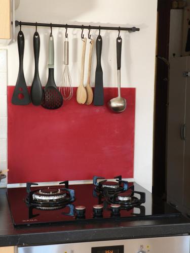 a stove top with utensils hanging on a wall at Chez Papoum et Lilou, vue imprenable avec terrasse au calme in Limoux