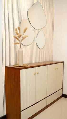 a cabinet with a vase and two mirrors on a wall at Spacious 3BR Luxury Apartment Trizen Colombo 2 Near City Centre in Colombo