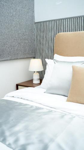 a bed with white sheets and a lamp on a table at Spacious 3BR Luxury Apartment Trizen Colombo 2 Near City Centre in Colombo