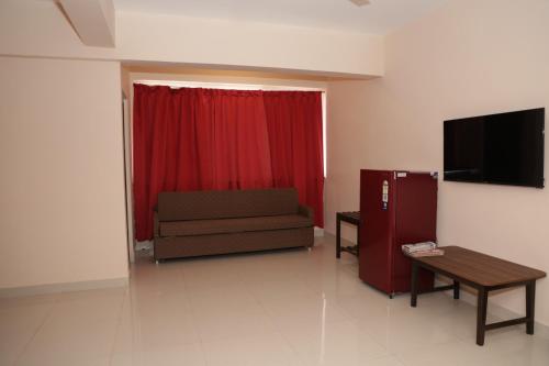 a living room with a couch and a red curtain at Nazri Hotel - Near Arambol Beach in Arambol