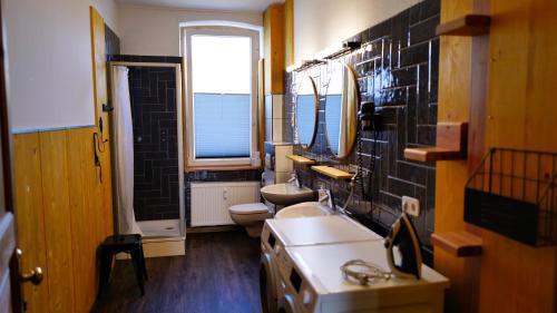 a bathroom with two toilets and two sinks at Gasthof Wedding in Bielefeld