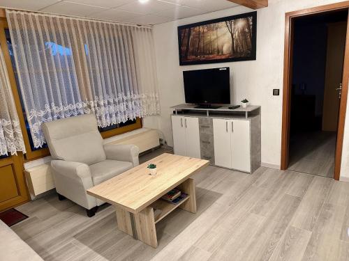 a living room with a couch and a table and a television at Pension Raststüb'l in Sorge