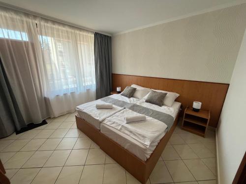 a bedroom with a large bed and a large window at Hegyalja Fogadó in Sárospatak
