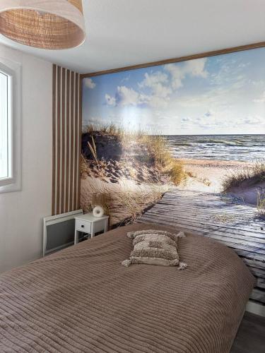 - une chambre avec un lit et une fresque murale représentant la plage dans l'établissement Appartement 2 chambres cosy, à La Grande Motte