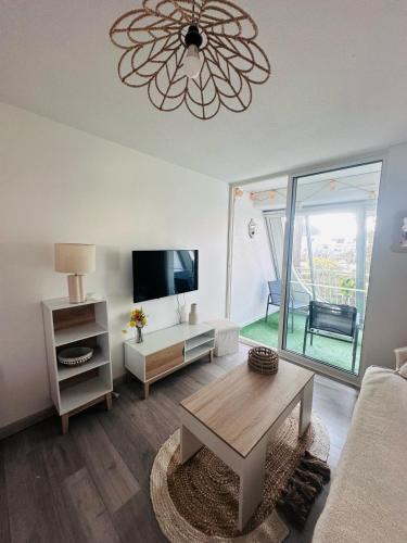 un salon avec un canapé et une table dans l'établissement Appartement 2 chambres cosy, à La Grande Motte
