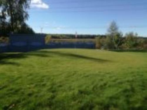 a field of green grass with a bridge in the background at Detached house with everything you need in Dagsmark