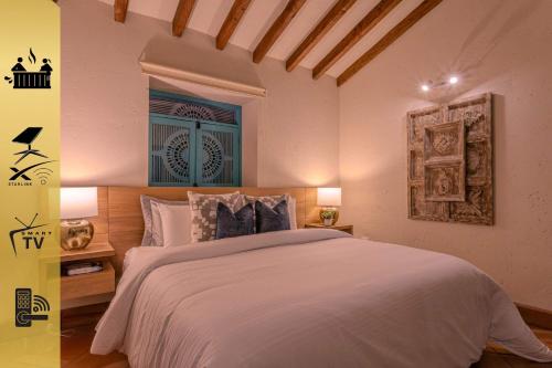 a bedroom with a white bed and a window at Vista Bonita - Hacienda Guatape in Guatapé