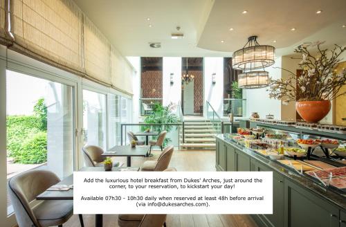 a large kitchen with a table and chairs at Dukes' Apartments Grand Place - by Dukes' Hotel Collection in Bruges