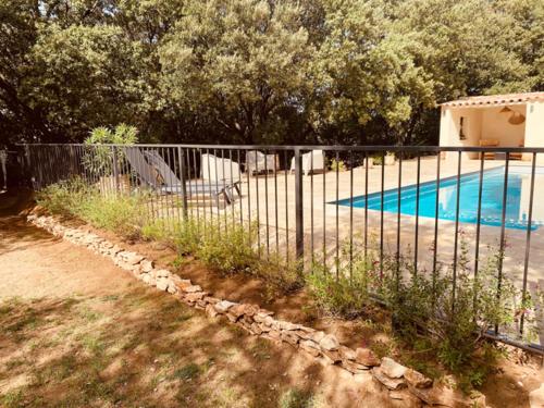 une clôture en face d'une piscine dans l'établissement Maset de caractère à Saint Siffret - Mas des Chênes -, à Saint-Siffret