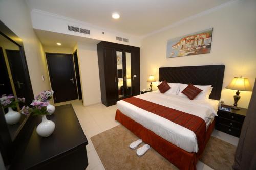 a hotel room with a large bed and a desk at Alain Hotel Ajman in Ajman 