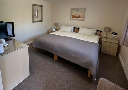 a bedroom with a large bed and a television at Newent Golf Club and Lodges in Newent