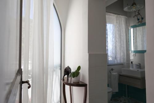 a bathroom with a sink and a toilet and a window at La Tua Terrazza in Costiera in Albori