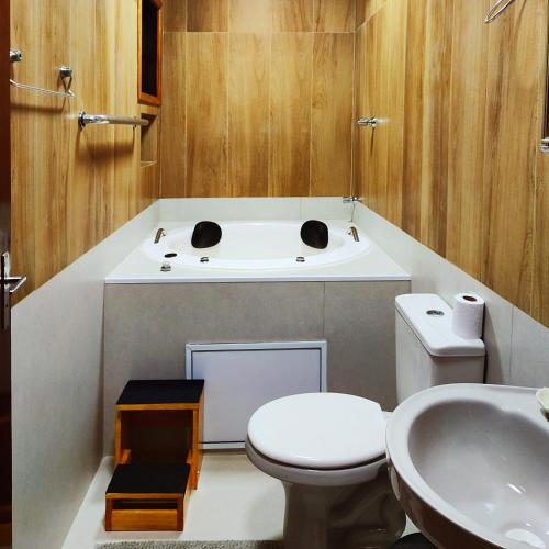 a bathroom with a toilet and a sink at Pousada Casa dos Sonhos in Campos do Jordão