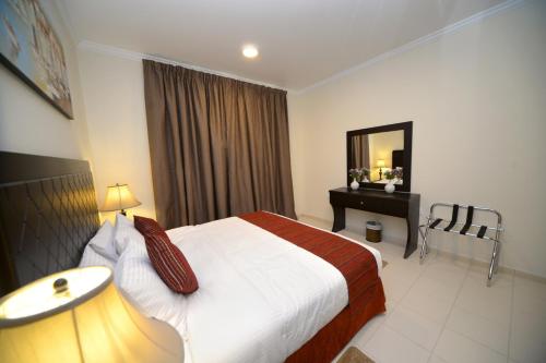 a hotel room with a bed and a mirror at Alain Hotel Ajman in Ajman 