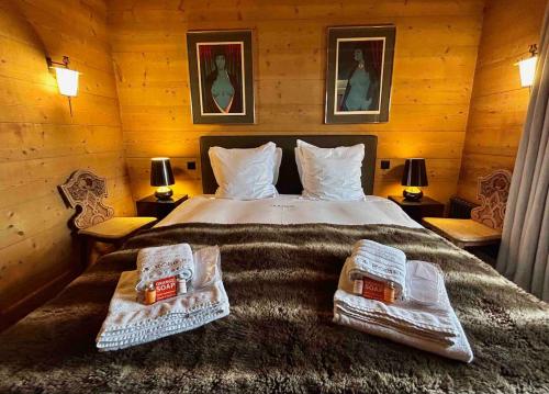 a bedroom with a large bed with two pillows on it at Unique, High-Design 6 Bedrooms Chalet in Villars Centre in Ollon