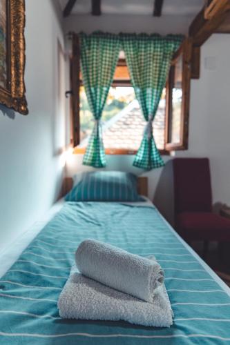a bed with two towels on it with a window at Konak Dobri Potok in Krupanj