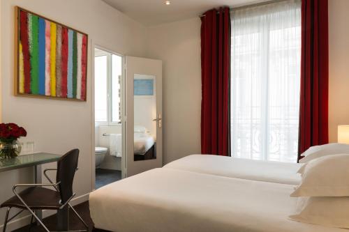a hotel room with a bed and a bathroom at Hôtel Albe Saint Michel in Paris