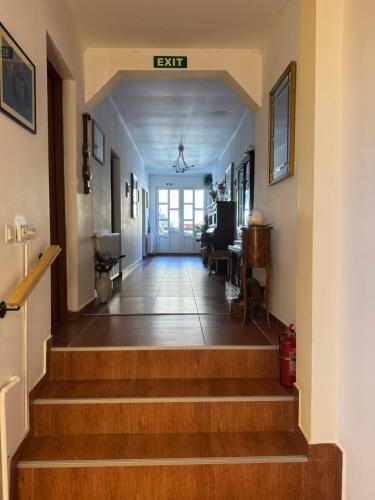 a hallway with stairs with a exit sign on the wall at Casa Anastasia - Moieciu de Sus in Moieciu de Sus