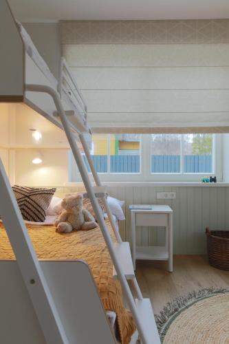 a teddy bear sitting on a bed in a bedroom at Vila 44 in Druskininkai