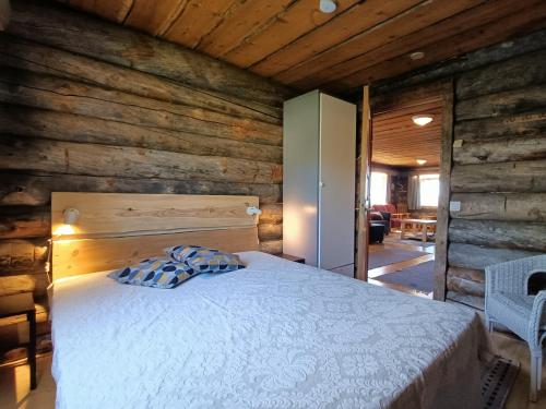 Un dormitorio con una cama en una cabaña de troncos en Kuusanka, en Syöte