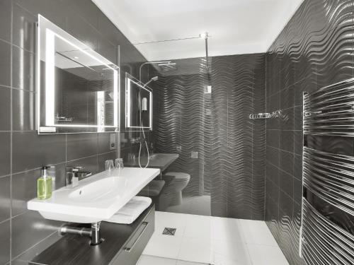 a black and white bathroom with a sink and a mirror at Wharton Park Golf & Country Club in Bewdley