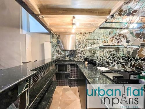 une cuisine avec un comptoir noir dans une pièce dans l'établissement Urban Flat 09 - Stylish Triplex Champs-Elysees, à Paris