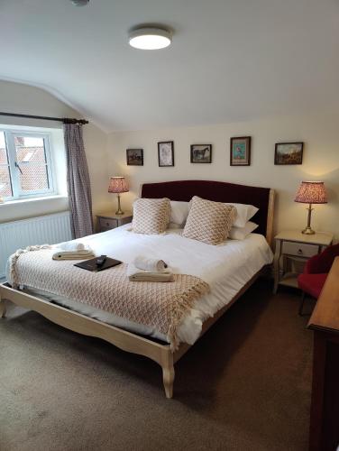 a bedroom with a large bed with two towels on it at The Royal Oak in Gillamoor