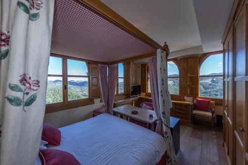 Un dormitorio con una cama, un escritorio y ventanas. en Castello Alidosi, en Castel del Rio