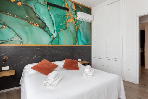 a bedroom with a white bed with two pillows on it at New Elegance Suites Guesthouse in Oristano