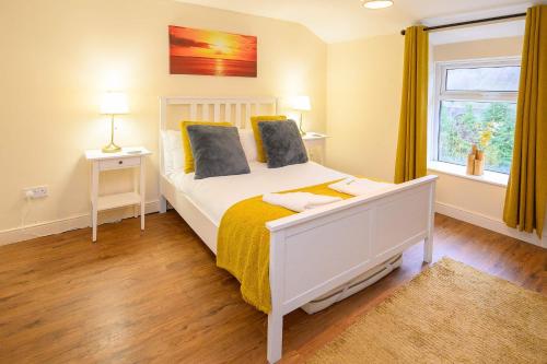 a bedroom with a white bed and a window at LLAREGGUB Amazing House In Afan Forest With Breath-Taking Views By StayStaycations in Port Talbot
