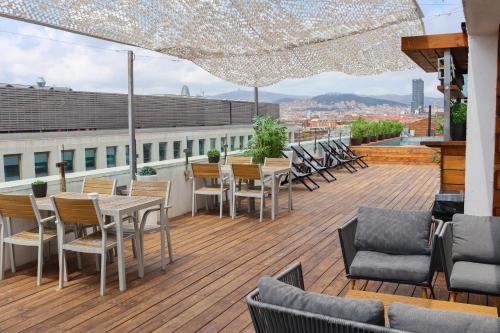 a wooden deck with tables and chairs on a roof at Eurohotel Diagonal Port in Barcelona