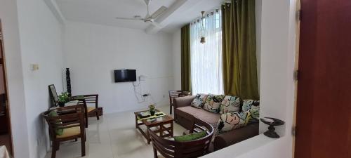 a living room with a couch and chairs and a window at Rose Villa in Malabe