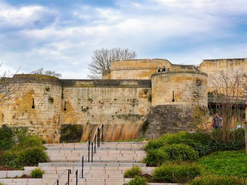 a large stone wall with stairs in front of it at ibis Styles Caen Centre Historique in Caen