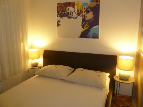 um quarto com uma cama com dois candeeiros em Apartment Adagio em Zagreb