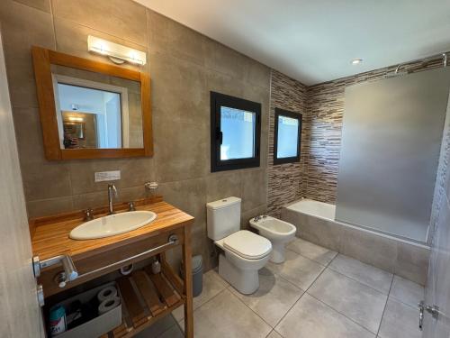 a bathroom with a sink and a toilet and a tub at Departamentos Estancia Los Ñires in San Martín de los Andes