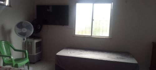 a bedroom with a bed and a window and a fan at Lar YAMAGUCHI COP 30 in Belém
