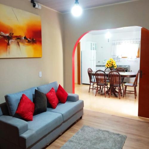 a living room with a blue couch with red pillows at Pousada Casa dos Sonhos in Campos do Jordão