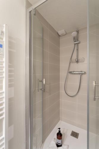 une salle de bain avec une douche avec une porte vitrée dans l'établissement Les Sablons - Magnifique Vue Port, à Saint-Malo