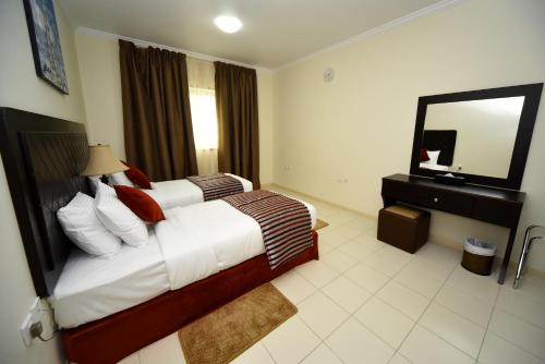 a hotel room with a bed and a mirror at Alain Hotel Ajman in Ajman 