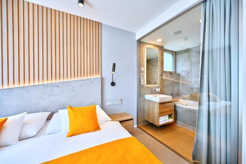 a bedroom with a bed and a bathroom with a tub at Wellness Hotel Fénix in Liberec
