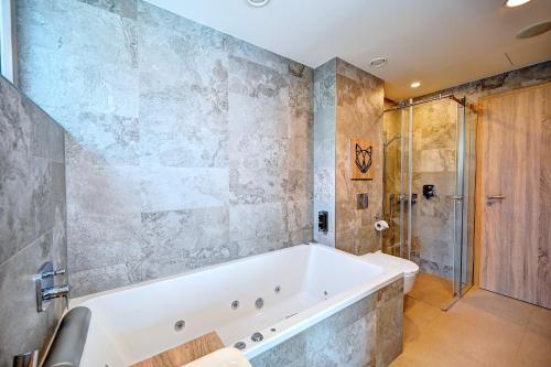 a bathroom with a large tub and a shower at Wellness Hotel Fénix in Liberec