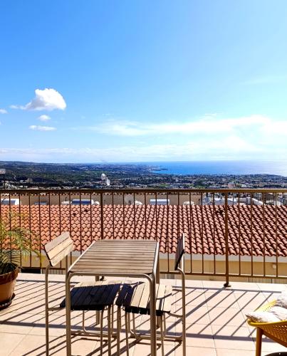 a table and chairs on a balcony with a view at Green Oasis Penthouse in Peyia