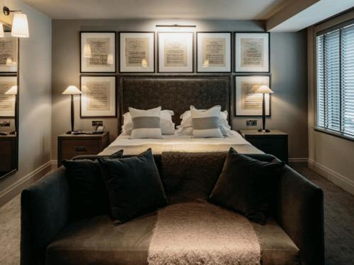 a bedroom with a bed with a couch and pictures on the wall at Dakota Leeds in Leeds