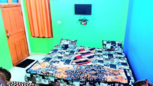 a bedroom with a bed and a green wall at radhe ji homestay AC or non ac in Ayodhya
