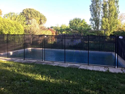 une piscine entourée d'une clôture dans l'établissement Charmante villa en Provence - Au Pré des Cyprès, à Mollégès