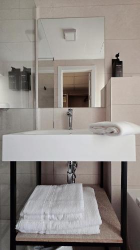 a bathroom with a white sink and a mirror at Q-Royal Skylounge in Playa de Palma