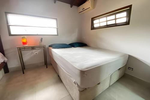 ein kleines Schlafzimmer mit einem Bett und einem Fenster in der Unterkunft Linda Casa Piscina no Sertão de Cambury - SP (2) in Camburi