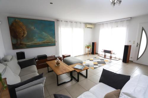 un salon avec des canapés blancs et une table dans l'établissement Saint Cyprien Jolie villa climatisee avec piscine et jardin, à Saint-Cyprien